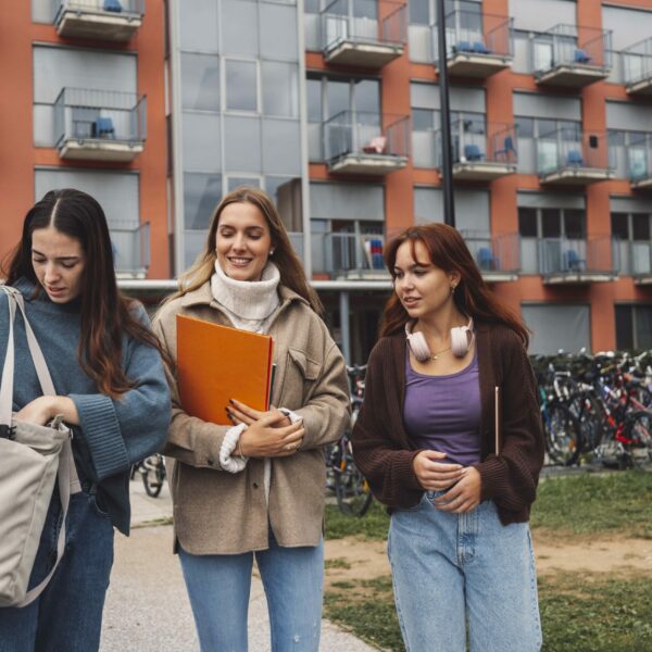friends-standing-against-building-min