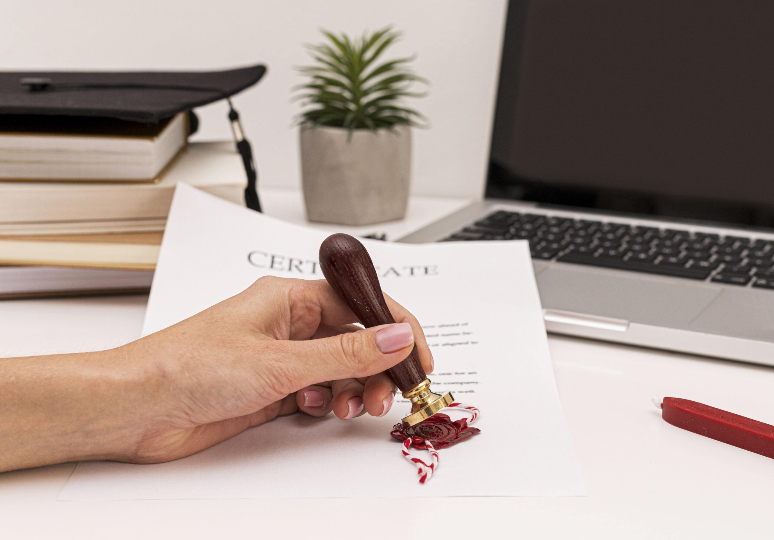 person-using-wax-seal-graduation-diploma-certificate-min
